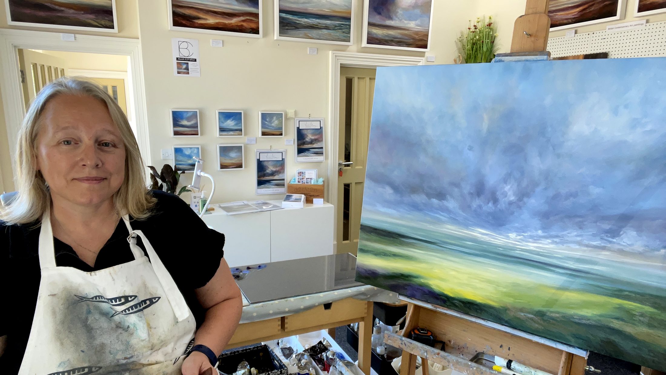 Andrea Mosey in her studio with one of her sky paintings